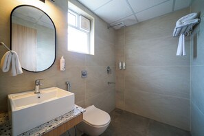 A modern bathroom with a sink, toilet, and shower.