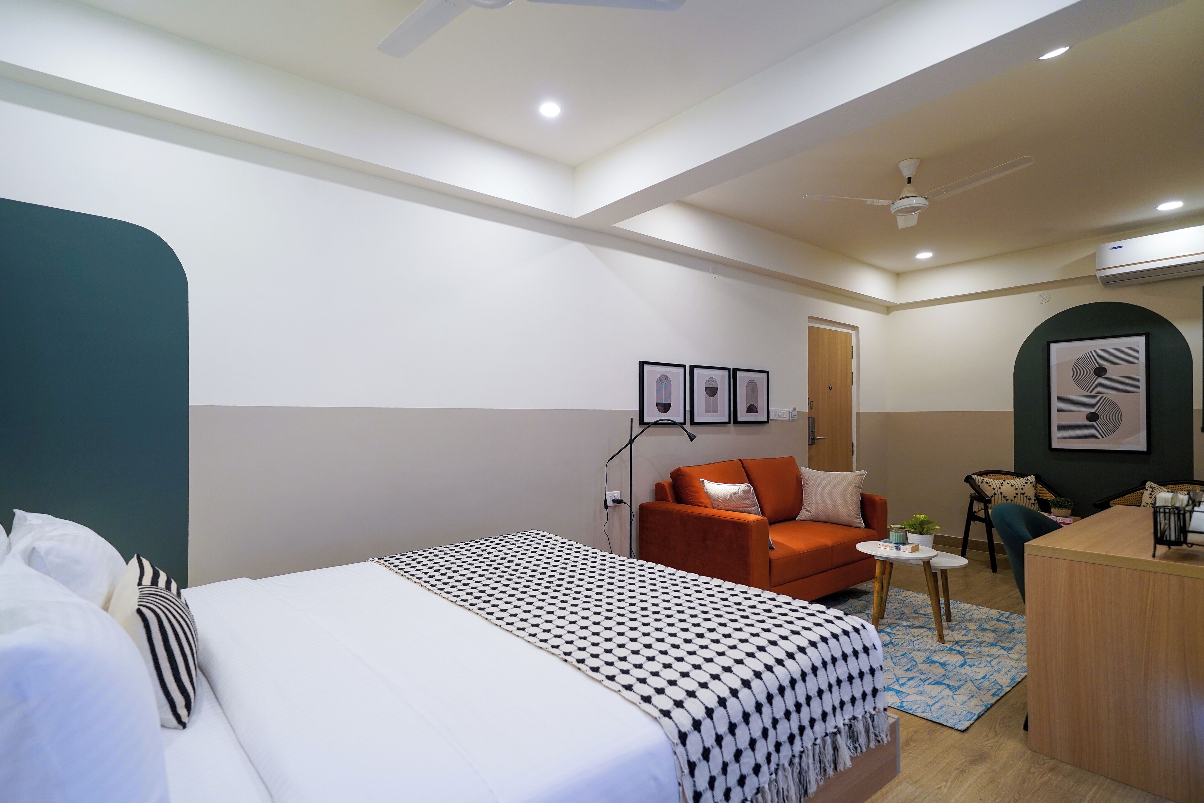 Una habitación de hotel con una cama, un escritorio, una silla y una mesita.