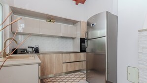 A modern kitchen with a stainless steel refrigerator, wooden cabinets, and a tiled backsplash. - Holiday home Lucic (Nin)