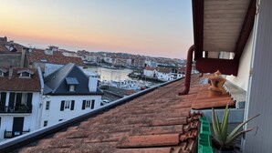 Una terraza con vista a un puerto y edificios.