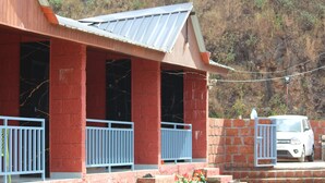 Un bâtiment rouge avec un toit en métal et des balustrades blanches.