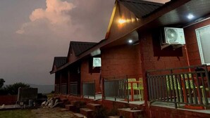 Un bâtiment à l’extérieur en briques, doté d’un toit en pente et d’un climatiseur fixé au mur.