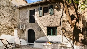 A stone building with a black door, a window with green shutters, and a small balcony. - Serene Retreat- Sleeps 4, Wifi, Courtyard (Lefkada)