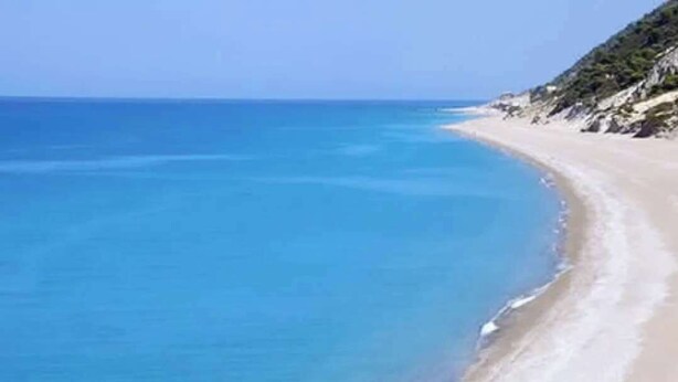 A beach with clear blue water and a person walking along the shore. - Serene Retreat- Sleeps 4, Wifi, Courtyard (Lefkada)