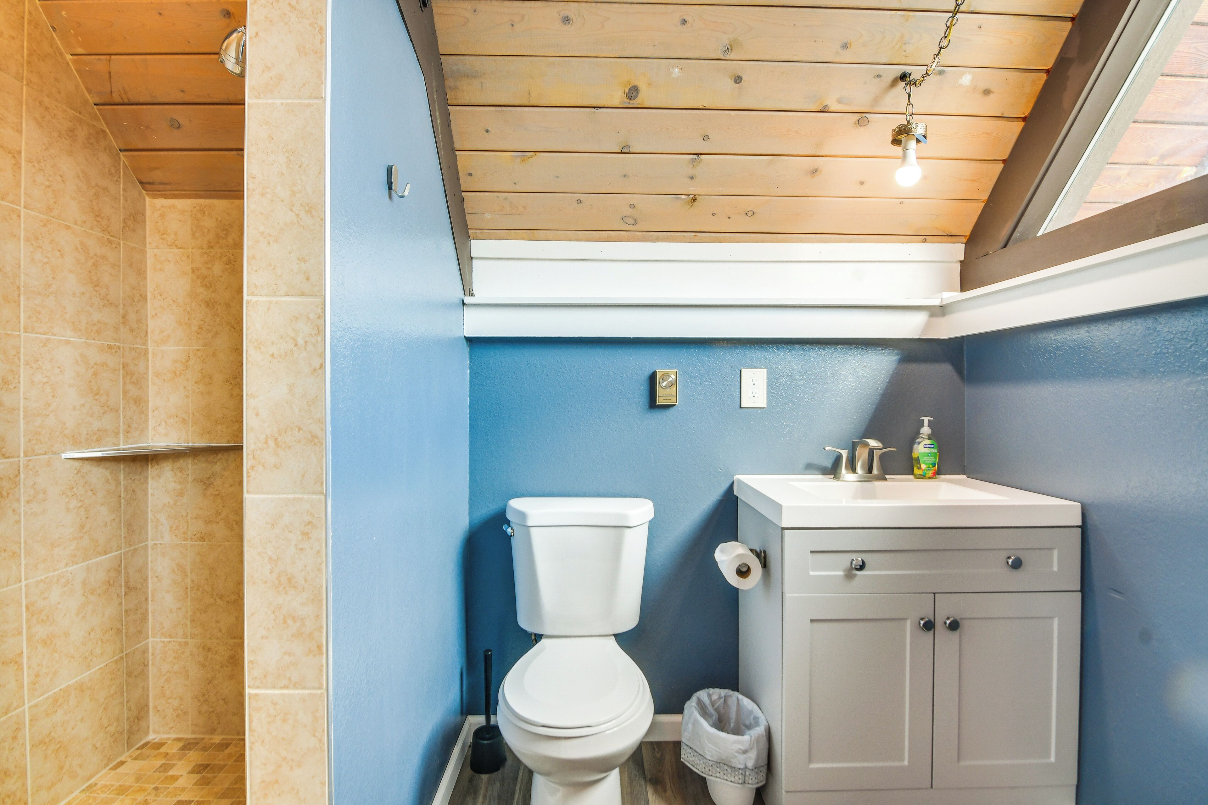 A bathroom with a toilet, sink, and shower area.
