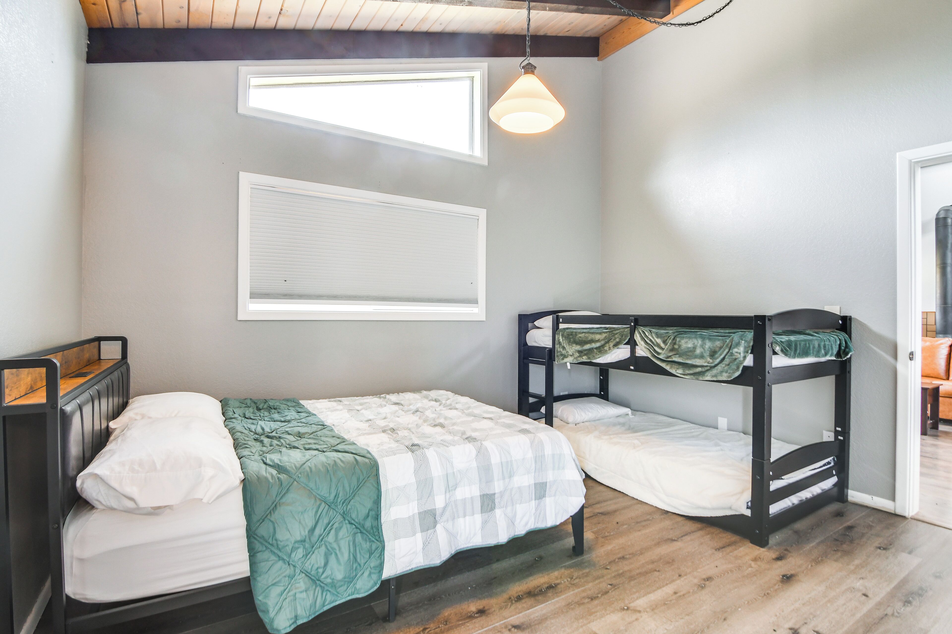 A bedroom with a bed, bunk beds, and a window.