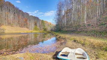 A boat on a riverbank with trees and a clear sky.