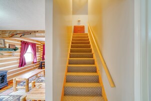 Una escalera de madera con un rellano alfombrado y barandilla de madera.