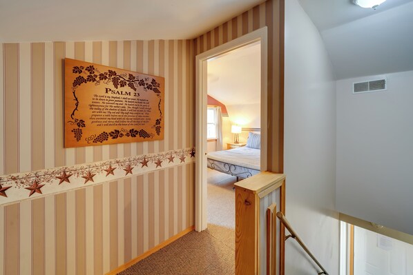 A hallway with striped wallpaper, a wooden bench, and a bed in the background. - Shared Pond at Retreat in Rosedale! (Rosedale)