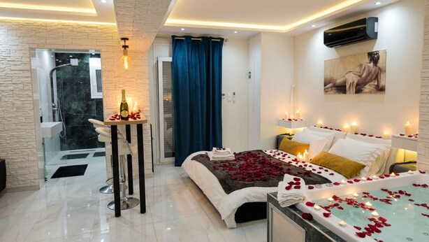 Ein modernes Hotelzimmer mit Bett, Badewanne und separater Dusche.