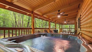 A hot tub in a wooden cabin with a view of the forest. - Beautiful Three Bedroom Cabin Directly On Cosby Creek (Cosby)