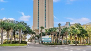 A tall hotel building with a sign reading "Sand Dunes Resort" and "Villas, Suites & Condos." - Spacious Beachfront Condo at Sand Dunes Resort 1203 – Perfect Location with Top (Myrtle Beach)