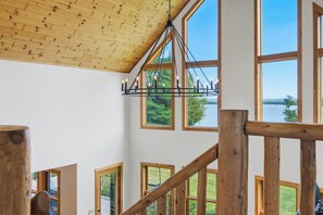 Un escalier en bois avec de grandes fenĂȘtres donnant sur un lac.