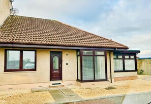 A residential building with a tiled roof, a front door, and windows with blinds. - 2-beds, Sleeps 4 w/ Parking, 15 Mins to St Andrews (Anstruther)