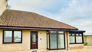 A single-story house with a tiled roof, a front door, and two windows with blinds. - 2 Bedroom, Cozy Coastal Retreat in Anstruther (Anstruther)