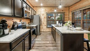 Una cucina moderna con pareti in legno, elettrodomestici in acciaio inossidabile e un'isola centrale.