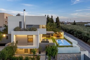 A modern two-story house with a swimming pool, outdoor seating, and a well-maintained garden. - Villa Crystal Sun by Estia (Heraklion)