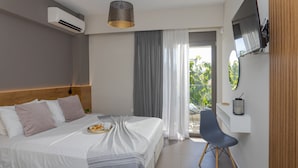 Une chambre d’hôtel moderne équipée d’un lit, d’une chaise, d’une télévision et d’un balcon avec vue.