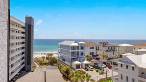 Un hôtel situé sur la côte, avec plusieurs étages, un parking et une vue sur la plage et l’océan.