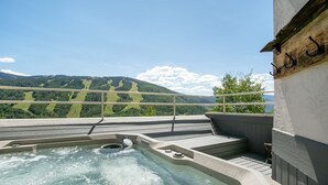 A hot tub with a view of a mountain landscape.