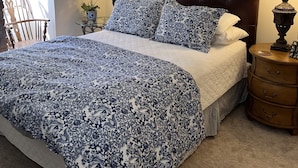 A bedroom with a large bed, a wooden headboard, and three framed pictures on the wall. - Valley Condos A25 3 Bedroom Condo (Vail)
