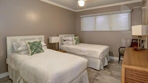 A bedroom with two beds, a nightstand, a lamp, and a window with blinds. - Royal Mauian, #116^ 2 Bedroom Condo (Kihei)