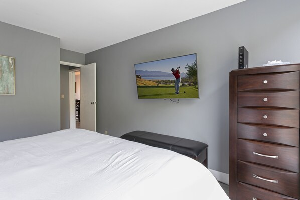 A bedroom with a bed, a television mounted on the wall, a wooden dresser, and a bench. - Simba Run 1525 2 Bedroom Condo (Vail)