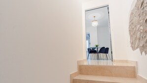A staircase leading to a dining area with a chandelier and a plant. - Residence Piccolo Lord 2 - Italian Homing (Calcinato)