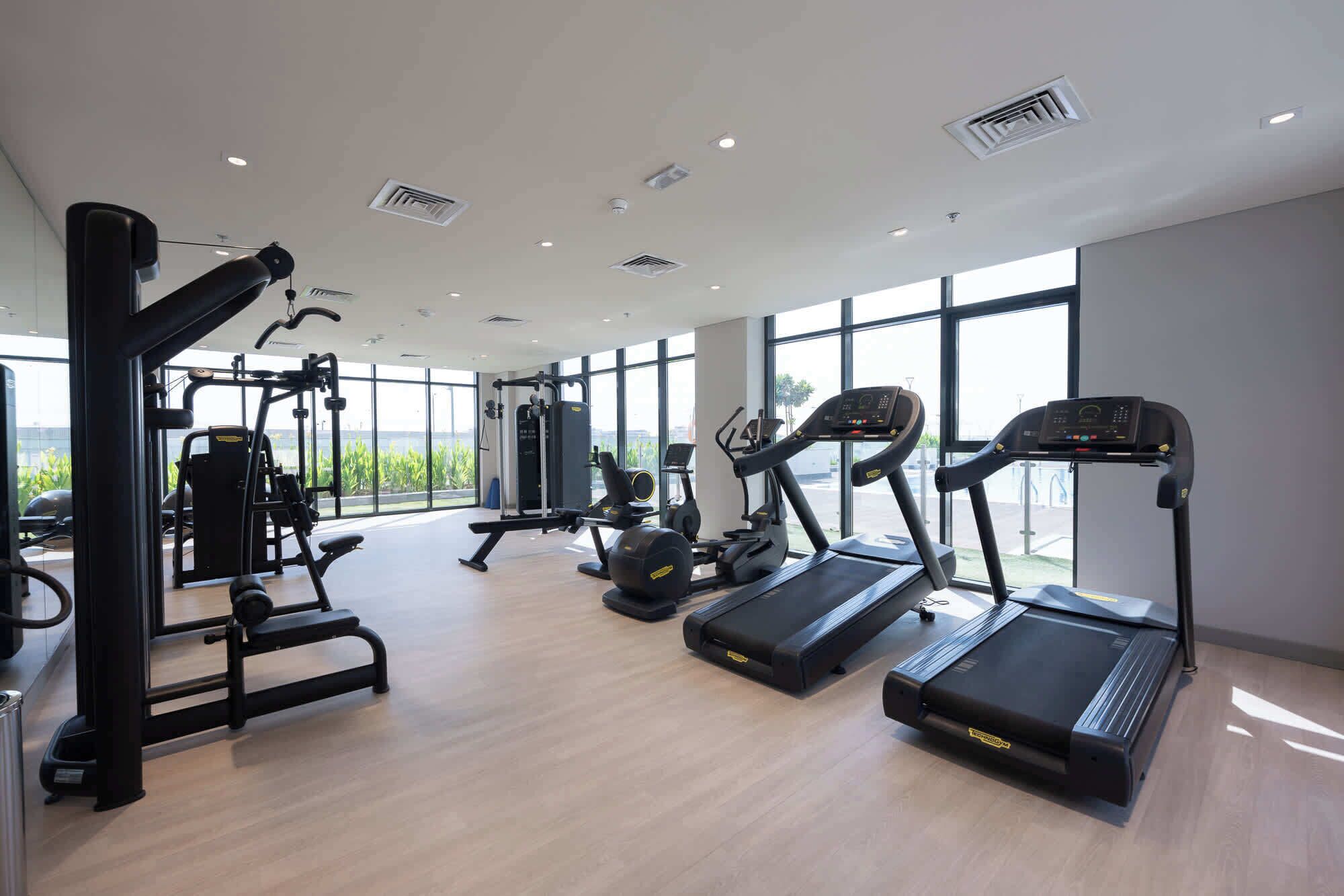 Ett modernt gym med löpband, crosstrainers och styrketräningsutrustning.