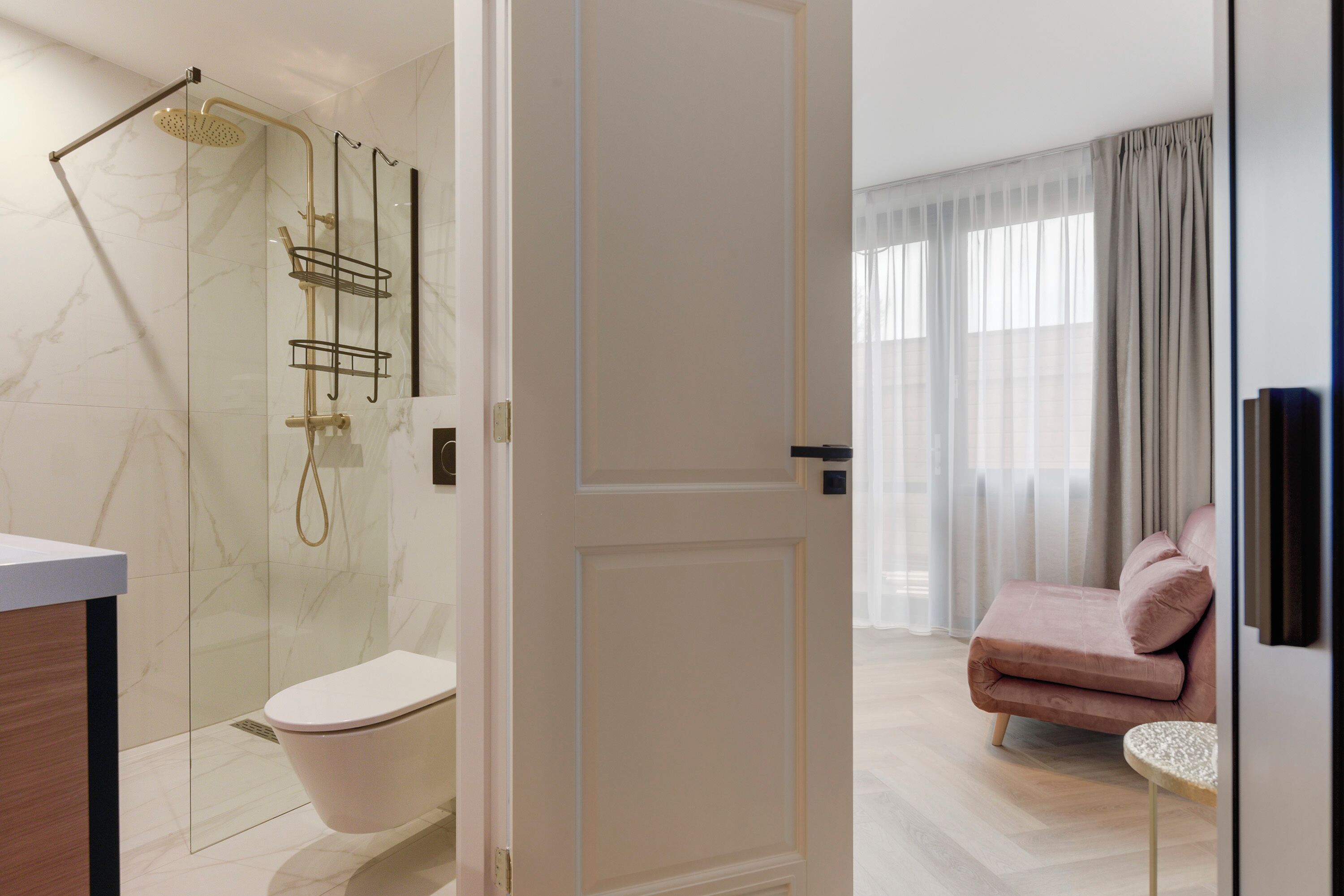 A modern bathroom with a glass-enclosed shower, a toilet, and a vanity.