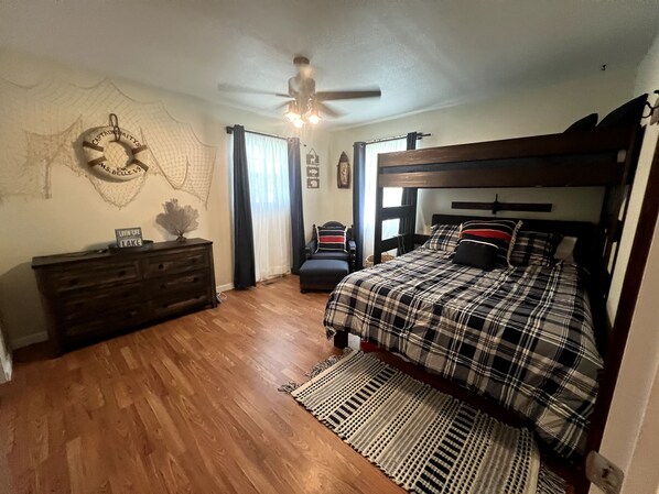 A bedroom with a wooden bed, a dresser, a ceiling fan, and a rug. - Cozy Home - Fire Pit - Seasonal Fishing (Williford)