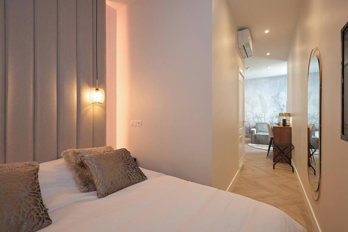 A hotel room with a large bed, a desk with a chair, and a view of the outdoors.