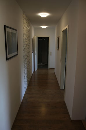 Stunning hallway with framed artwork and a decorative brick pattern leads to a door.