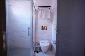 A bathroom with a toilet, a bidet, a towel rack, and a mirror. - Keeper  (Istanbul)