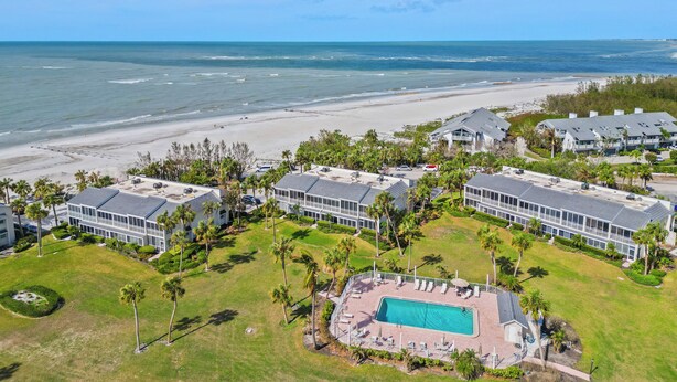 A beachfront hotel with multiple buildings, a swimming pool, and a beach view. - Gulf Views & Cozy Comfort w Large Lanai Tern's Nest #22 Condo by RVA (Longboat Key)