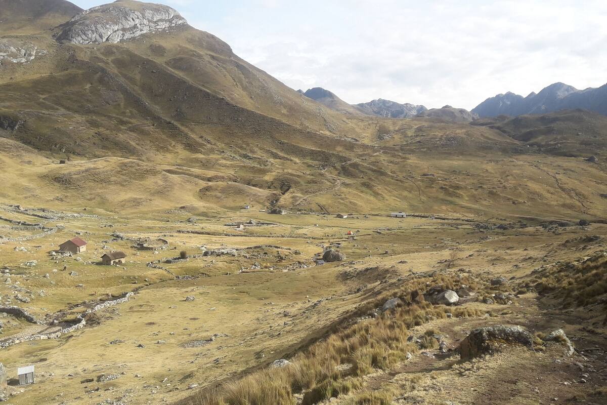 A mountainous landscape with scattered buildings and a valley.