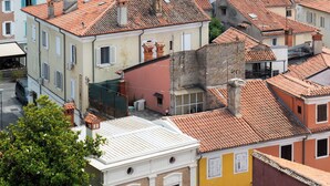 A historic town with a prominent tower and red-tiled roofs. - Apartmani Igor (Koper)