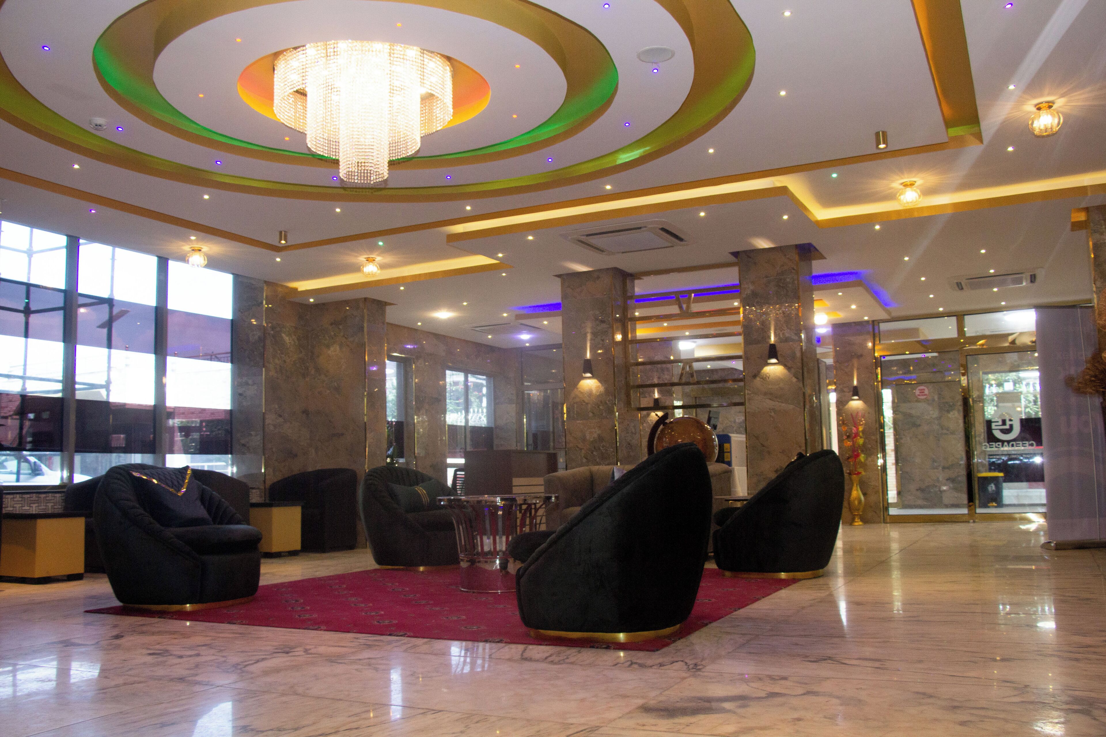 A lobby with modern seating, a chandelier, and a marble floor.