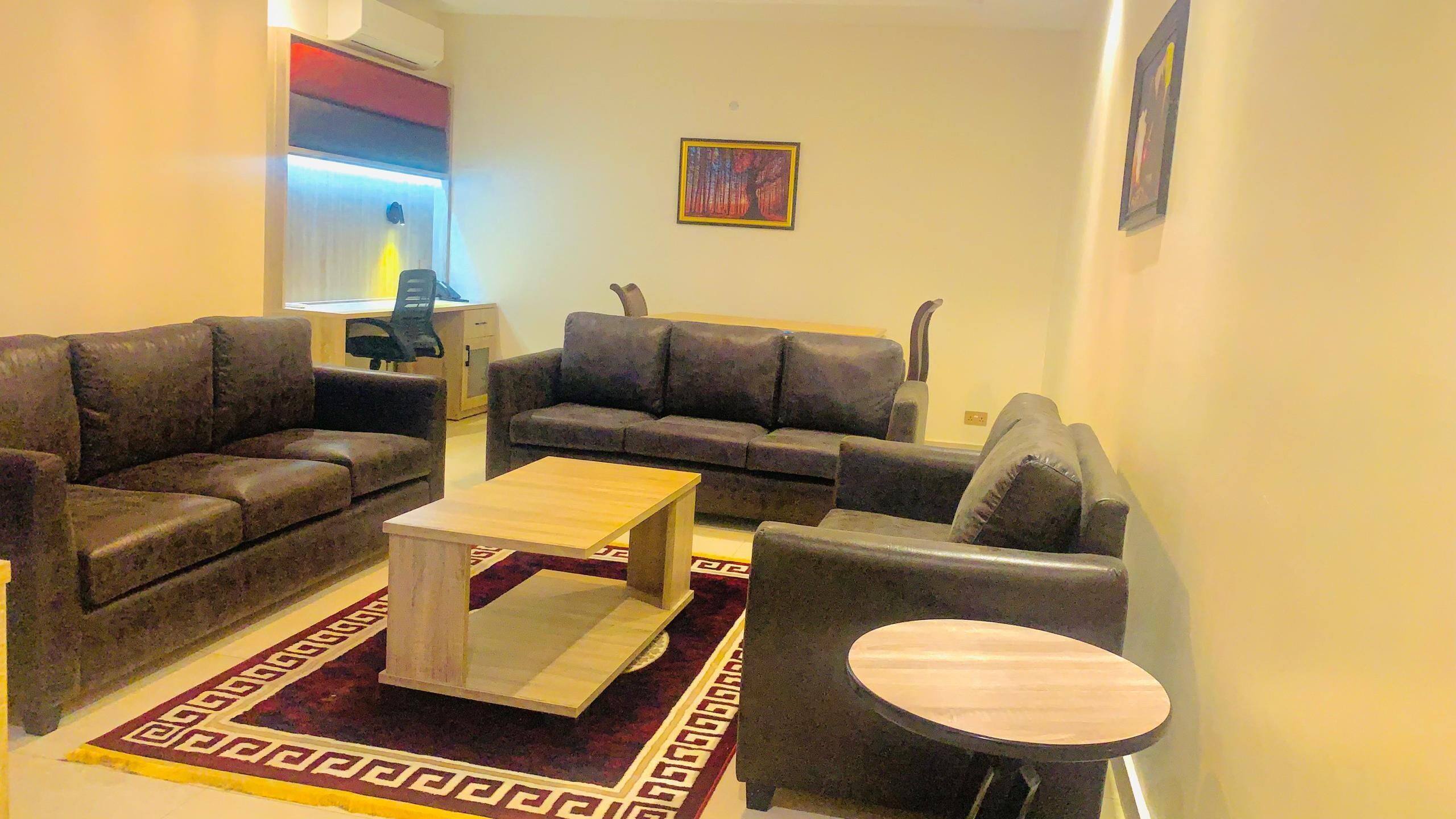 Una sala de estar con dos sofás, una mesa de centro y una mesita redonda.