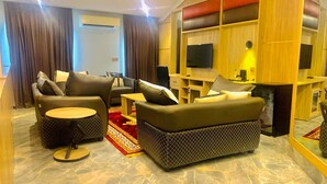 A modern living room with a sofa set, a coffee table, and a TV. - Ceedapeg Hotels (Uyo)