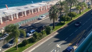 Une route côtière bordée d’une plage et de palmiers.