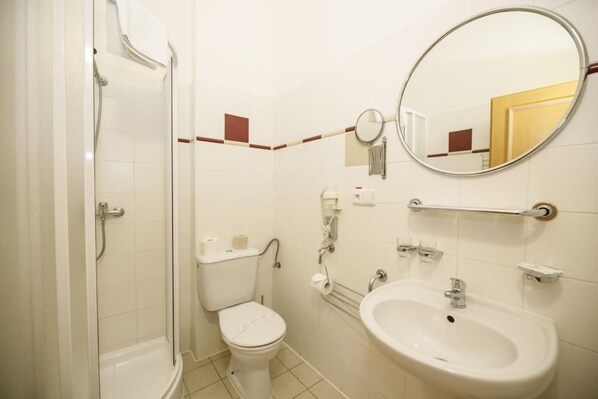 A bathroom with a toilet, sink, and shower.
