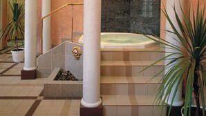 A spa area with a hot tub, marble columns, and potted plants. - Wellness hotel Jean de Carro (Karlovy Vary)
