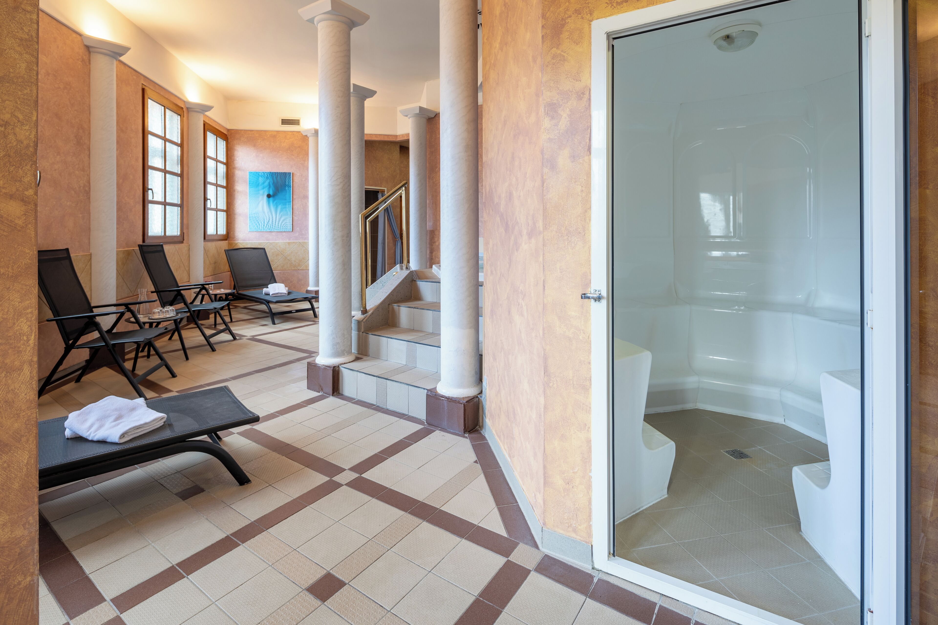A hotel lobby with a check-in counter, seating area, and a glass-enclosed shower room.