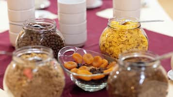 A table with various food items in jars and bowls, including cereal and dried fruits.