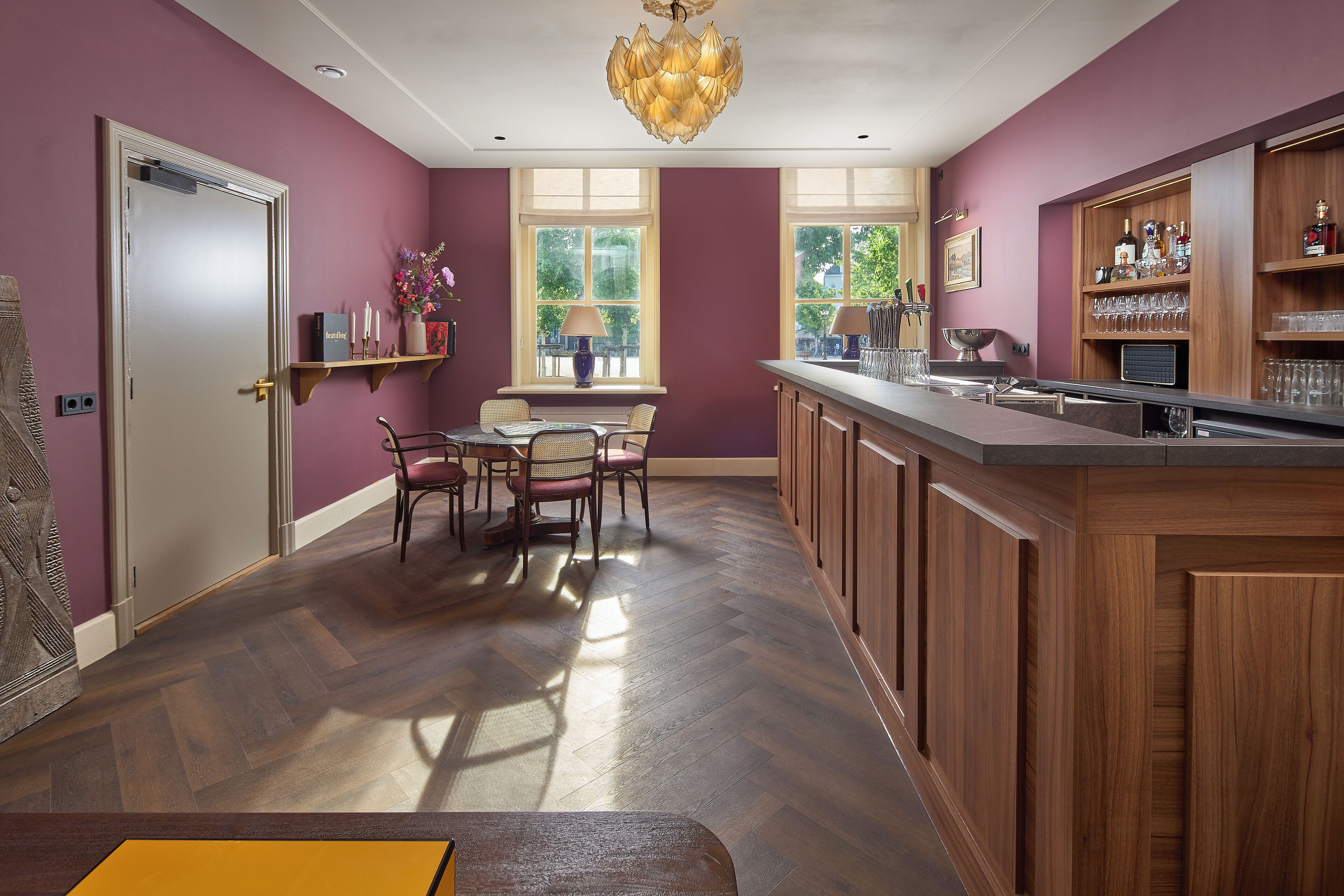 A modern kitchen with wooden cabinets, a bar area, and a dining set.
