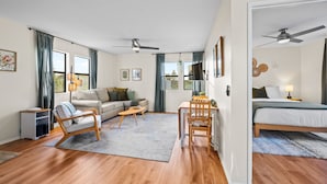 A modern, well-lit room with a sofa, a dining table, a chair, a bed, and a ceiling fan. - 25% Off Sept 24-27 Amazing Reviews, Walk To Beach* (Ventura)