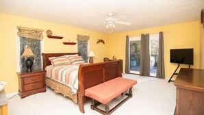 A bedroom with a bed, bedside tables, a bench, a ceiling fan, a TV, and a window with curtains. - Boats N Oats: Great family getaway, wifi, gentle lot, kayak (Moneta)
