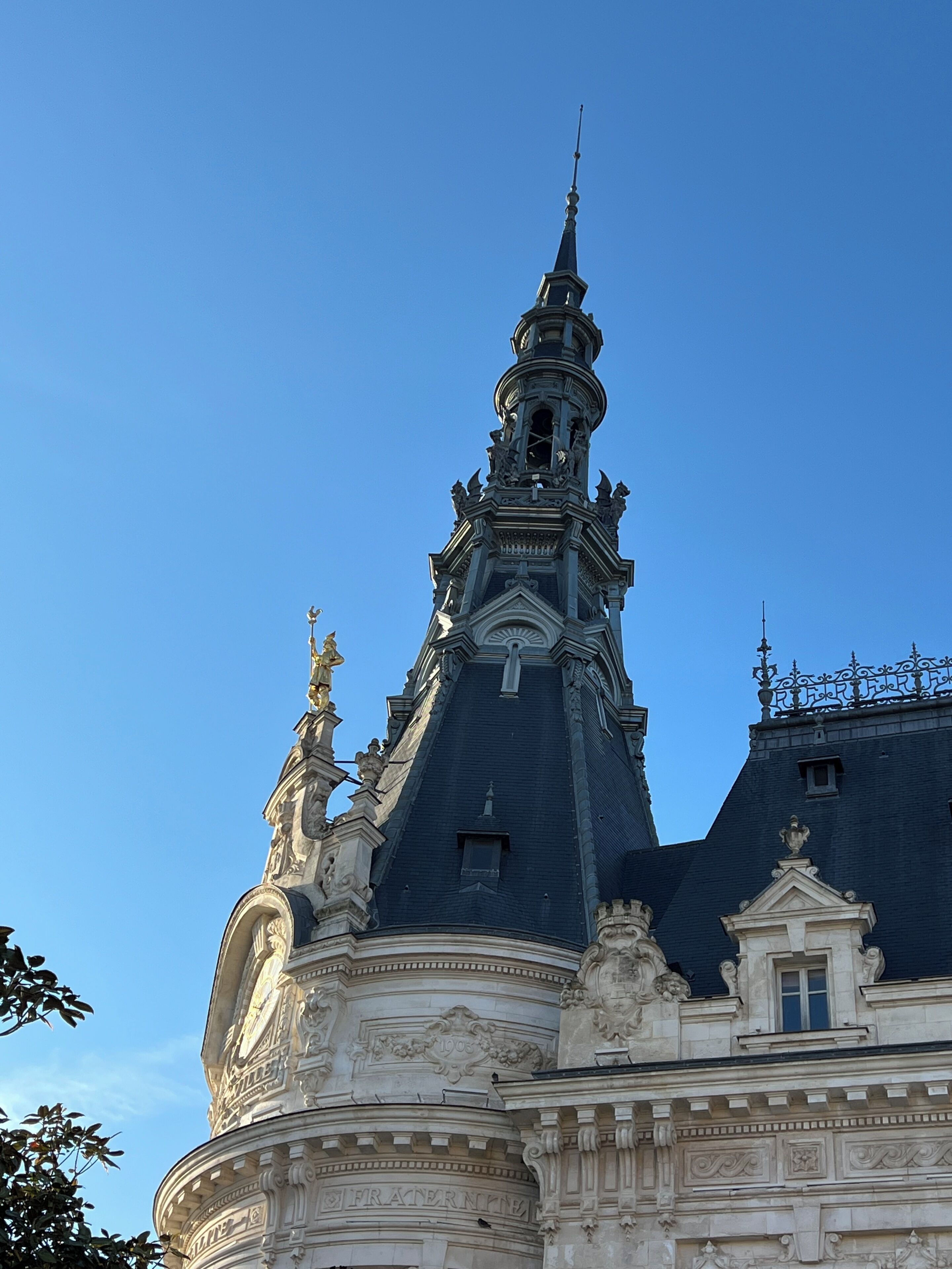 Un edificio histórico con arquitectura ornamentada, que incluye una torre destacada y detallados relieves.
