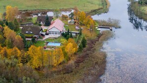 An aerial view of a house surrounded by autumn foliage and a body of water. - Apartment for two Only 20 m From Boruja Lake in Rekowo (Bytow)